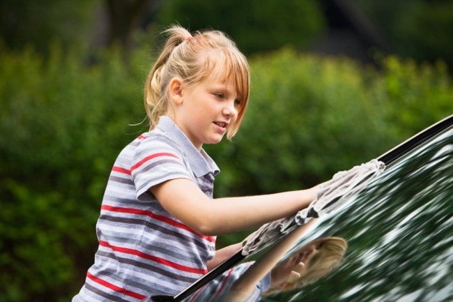 Young girl washing car