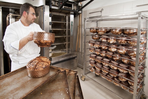 Baker loading cooling racks with bread